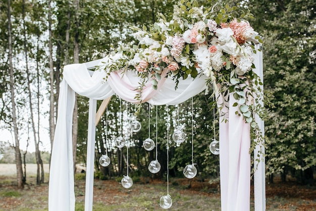 Décorer l'arche avec des fleurs et du tissu pour une cérémonie de mariage dans la nature