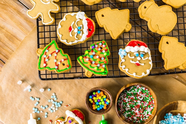 Décorer des biscuits au pain d'épice avec du glaçage royal et des bonbons colorés.