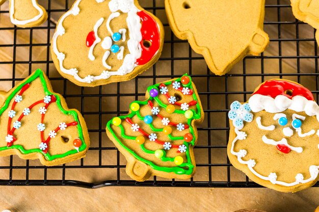 Décorer des biscuits au pain d'épice avec du glaçage royal et des bonbons colorés.