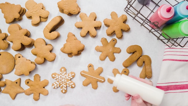 Décorer des biscuits au pain d'épice avec du glaçage royal pour Noël.