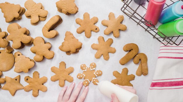 Décorer des biscuits au pain d'épice avec du glaçage royal pour Noël.