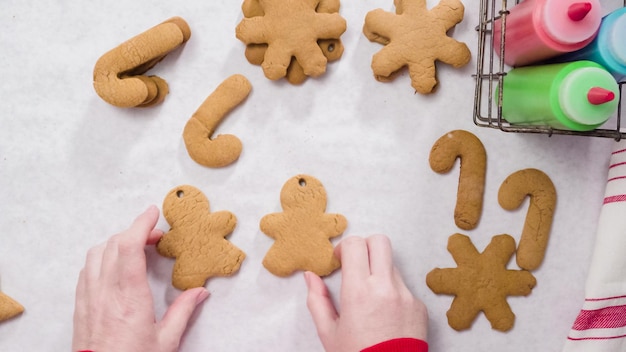 Décorer des biscuits au pain d'épice avec du glaçage royal pour Noël.