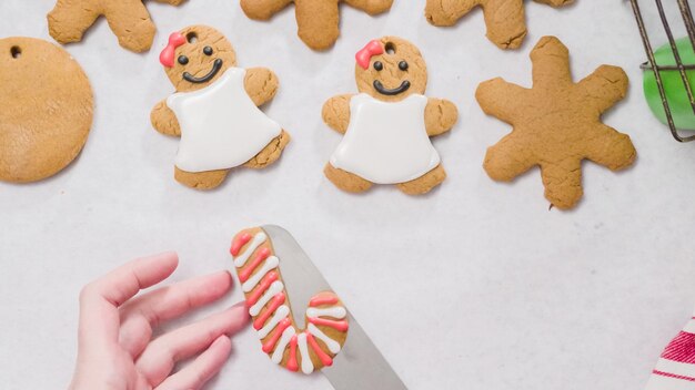 Décorer des biscuits au pain d'épice avec du glaçage royal pour Noël.