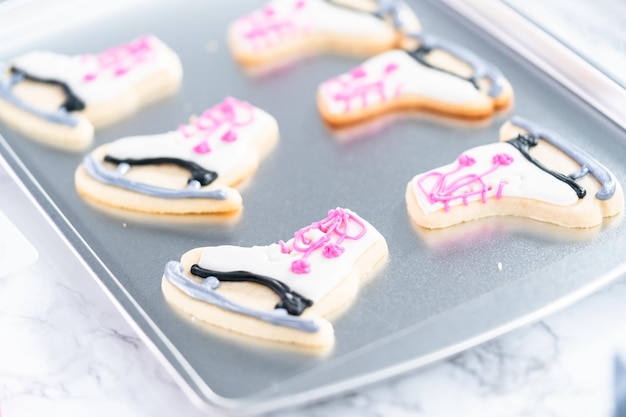 Décorer des biscuits au sucre en forme de patins artistiques avec du glaçage royal.