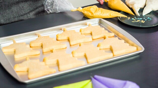 Décorer des biscuits au sucre de licorne avec du glaçage royal multicolore.