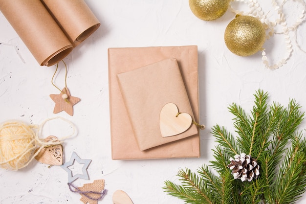 Décorer des cadeaux de Noël dans un style écologique, du papier pour l'emballage, un décor à partir de matériaux naturels et des coffrets cadeaux sur fond blanc, un décor fait maison pour Noël et le nouvel an