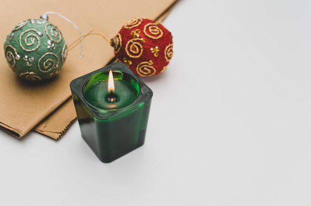 Décors de Noël avec bougie parfumée verte dans un verre sur fond blanc avec espace de copie