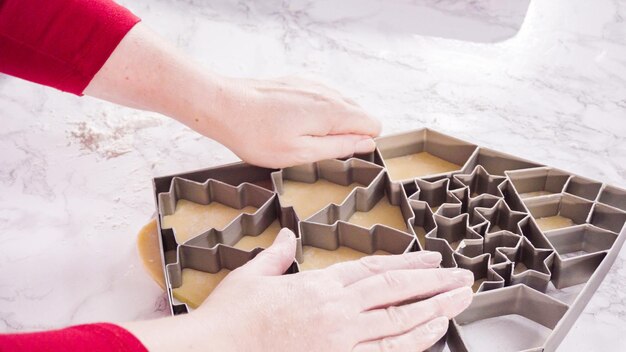 Découper des biscuits au sucre avec un emporte-pièce géant de Noël.