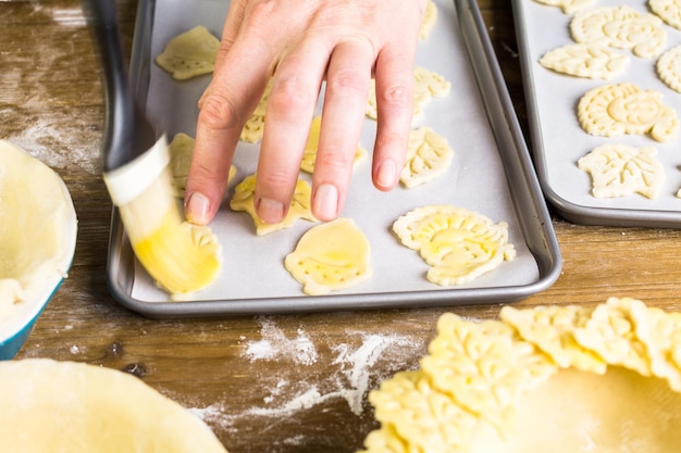 Découper des feuilles d'automne avec un tampon à biscuits pour décorer la tarte à la citrouille.