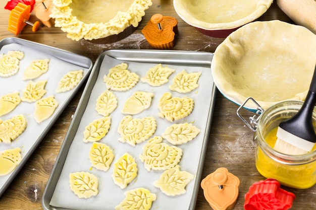 Découper des feuilles d'automne avec un tampon à biscuits pour décorer la tarte à la citrouille.