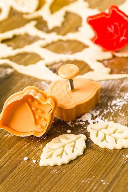 Découper des feuilles d'automne avec un tampon à biscuits pour décorer la tarte à la citrouille.