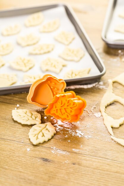 Découper des feuilles d'automne avec un tampon à biscuits pour décorer la tarte à la citrouille.