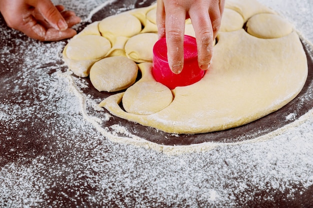 Découpez des cercles de pâte pour faire des petits pains sucrés, des dounuts.