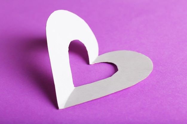 Découpez le coeur de papier blanc sur le fond violet