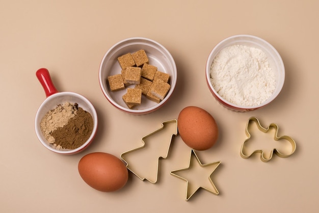 Découpez la forme de biscuit de pain d'épice sous la forme d'une étoile d'arbre de Noël et d'un bonhomme en pain d'épice et d'ingrédients pour les biscuits Oeufs Farine Sucre Épices