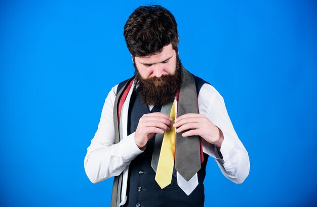 Découvrez la mode masculine à la mode dans notre boutique Homme barbu choisissant une cravate de luxe dans une boutique de vêtements pour hommes Vendeuse offrant un large choix de cravates les plus raffinées Boutique de vêtements et accessoires pour hommes