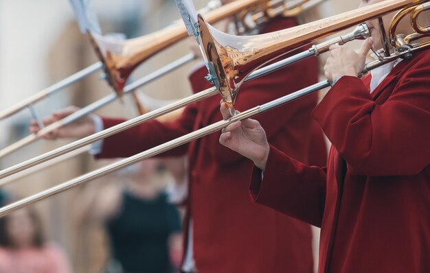 Un défilé d'instruments à vent d'hommes en costumes rouges jouant de la trompette