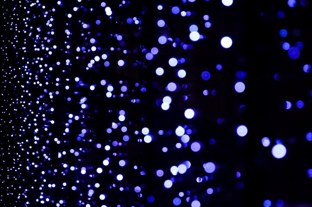 Défocalisé abstrait lumières de Noël bleu bokeh sur fond noir