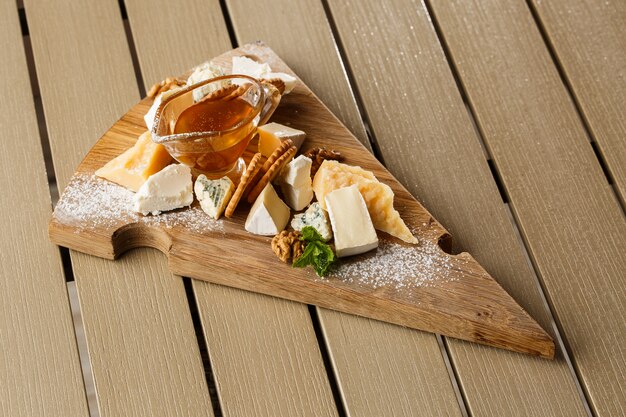 Dégustation de fromage sur une assiette en bois.