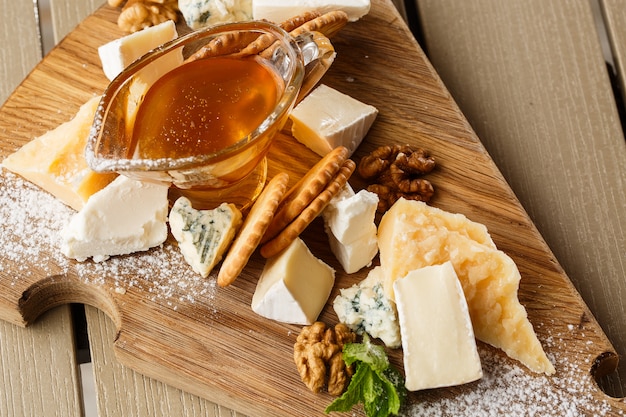 Dégustation de fromage sur une assiette en bois.