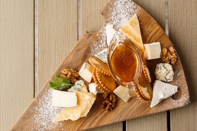 Dégustation de fromage sur une assiette en bois.