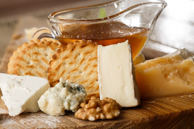 Dégustation de fromage sur une assiette en bois.