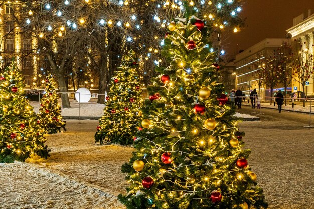 En dehors de l'arbre de Noël et du nouvel an avec une décoration lumineuse dorée lors d'une soirée en hiver