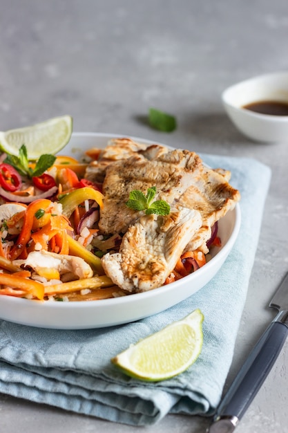 Déjeuner au bol de Bouddha avec poulet grillé et carotte, poivre, oignon, riz et herbes