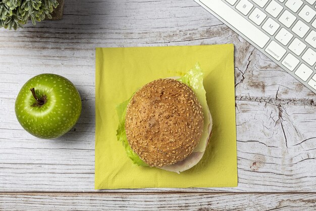 Déjeuner au lieu de travail sandwich sain près de l'ordinateur portable sur la table de travail. Cuisine à domicile pour concept de bureau