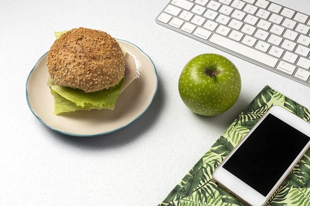 Déjeuner au lieu de travail sandwich sain près de l'ordinateur portable sur la table de travail. Cuisine à domicile pour concept de bureau