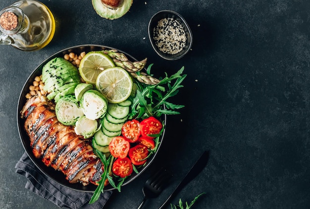 Déjeuner bol bouddha sain avec poulet grillé roquette avocat choux de bruxelles tomate concombre et pois chiche