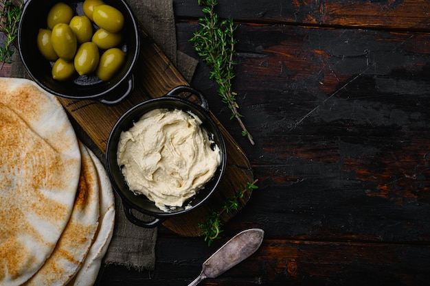 Déjeuner crémeux juif traditionnel de houmous situé sur une vieille table en bois sombre vue de dessus d'arrière-plan plat avec espace de copie pour le texte