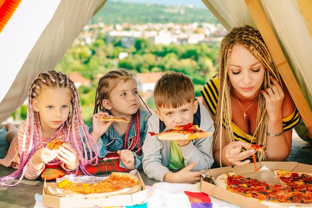 Déjeuner en famille en plein air Mère avec enfants dans la tente Camping familial Maman avec enfants s'amusant à l'extérieur Concept de vacances