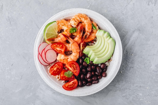 Déjeuner de fruits de mer sain Burrito aux crevettes épicées Buddha Bowl avec riz sauvage tomates et radis haricots noirs et avocat