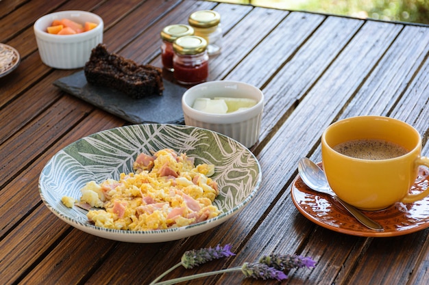 Déjeuner. Oeufs au jambon, tasse de café, portion de melon et gâteau aux biscuits (vue latérale).