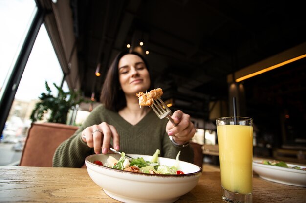 Déjeuner sain. Salade César et jus d'orange. Vue rapprochée. Concentrez-vous sur une tranche de poulet.