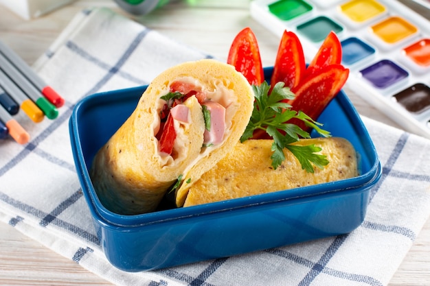 Déjeuner scolaire et papeterie sur la table. Conteneur à lunch avec déjeuner sain