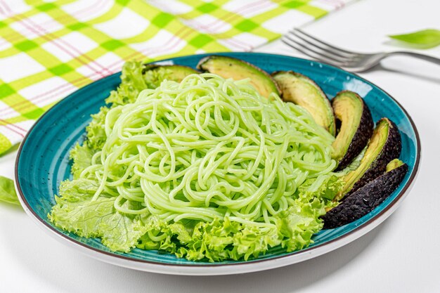 Déjeuner végétarien spaghettis verts avec avocado et laitue