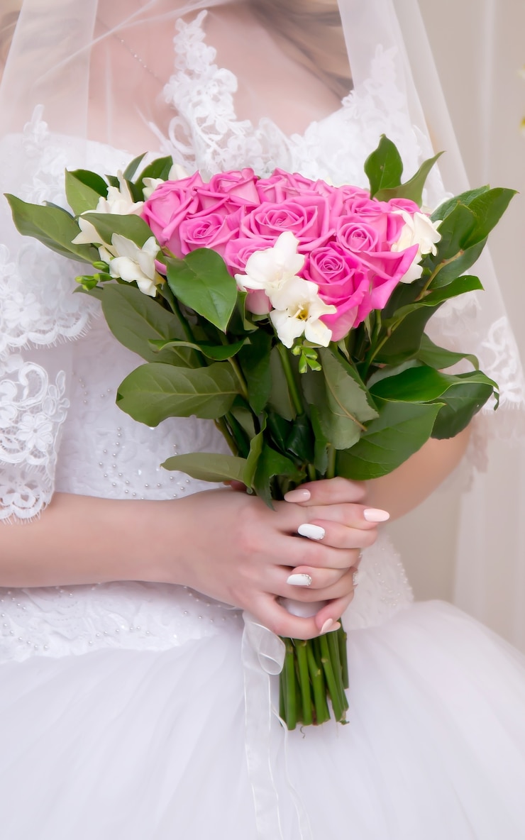Photo délicat bouquet de mariée de fleurs roses et blanches dans les mains de la mariée
