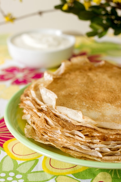 Délicates crêpes en résille avec de la crème sure.