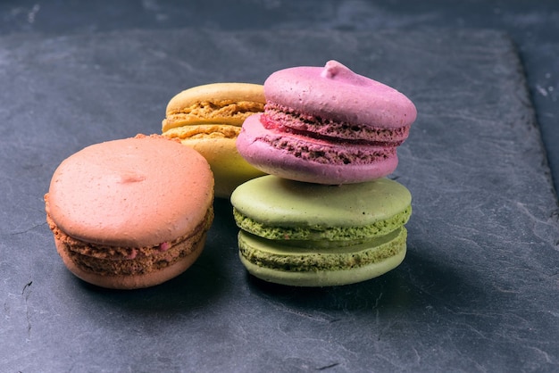 Une délicatesse sucrée française, des macarons sur fond sombre se bouchent.