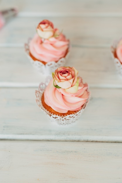 Délicats Muffins Savoureux Avec Une Crème Rose Décorée De Vrai Ros