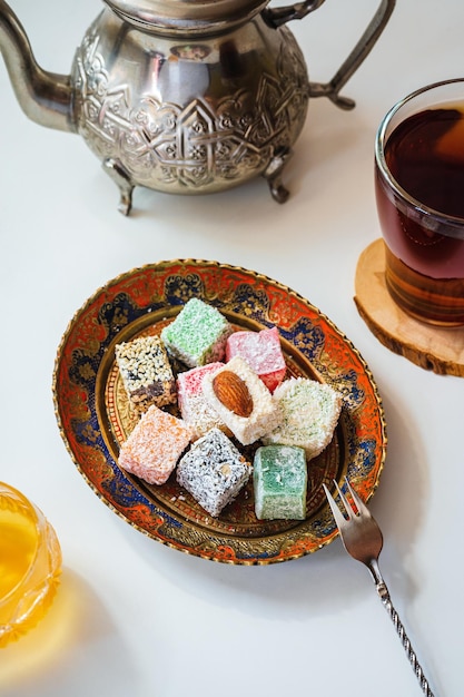 Délice turc sur une assiette vintage Théière marocaine miel et thé sur un tableau blanc