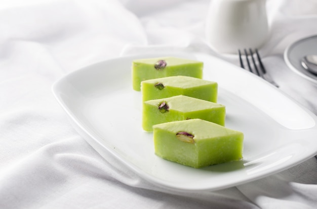 Délice turc traditionnel avec café au petit déjeuner. Dessert arabe pistaches halva et rahat lokum en plaque blanche sur table avec un espace pour le texte. délice turc.