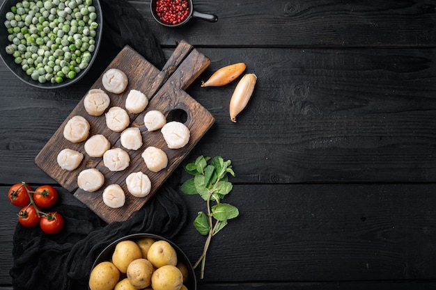 Délices de la mer, pétoncles aux pommes de terre, pois verts et menthe, vue du dessus, sur table en bois noir