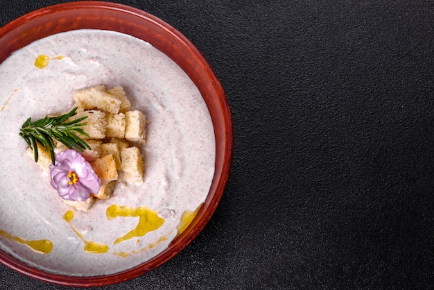 Délicieuse belle soupe aux champignons dans une assiette brune avec une cuillère en bois