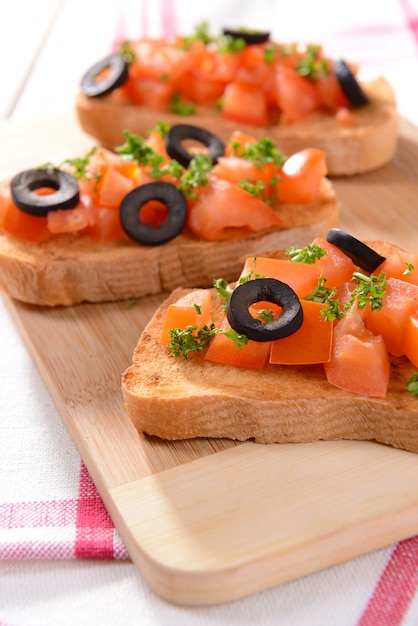 Délicieuse bruschetta aux tomates sur une planche à découper