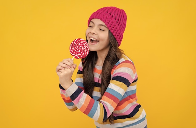 Délicieuse chanteuse adolescente heureuse tenir sucette sucette dame hipster enfant avec sucette colorée sucre candi sur bâton caramel magasin de bonbons douce vie d'enfance concept de chanter la dent sucrée