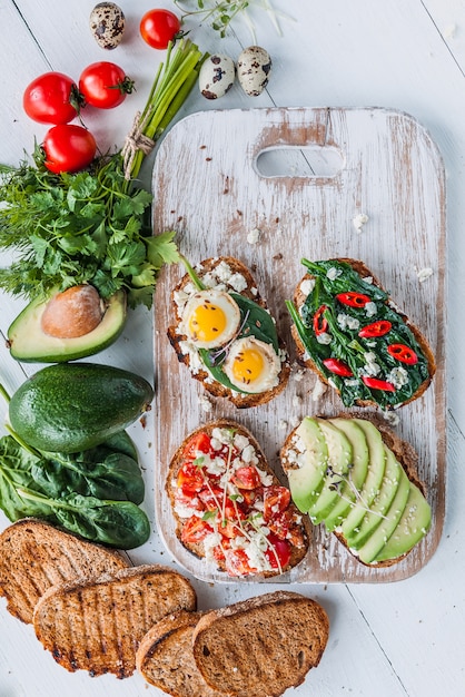 Délicieuse et délicieuse bruschetta aux tomates, épinards, feta avocat piment rouge et fromage bleu.