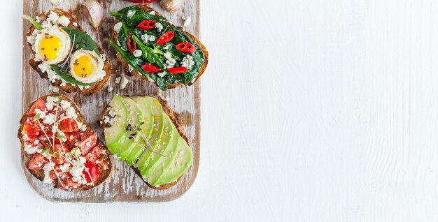 Délicieuse et délicieuse bruschetta aux tomates, épinards, feta avocat piment rouge et fromage bleu.